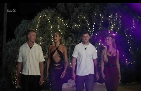 Four Love Island contestants walking at night.