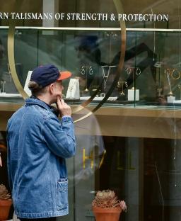 Man looking at jewelry in a shop window.