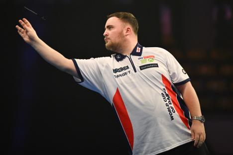 Luke Littler of England throwing a dart during a darts match.