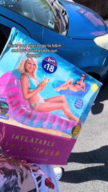 A person holding a B&M inflatable sun lounger box.