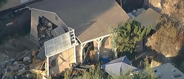 Aerial view of a damaged home and surrounding area.