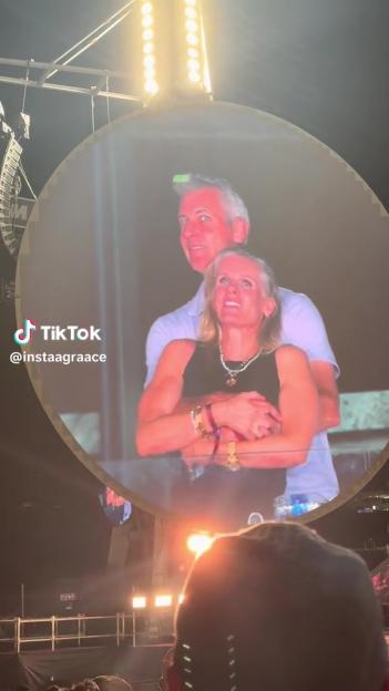 A large screen showing a man and woman embracing.