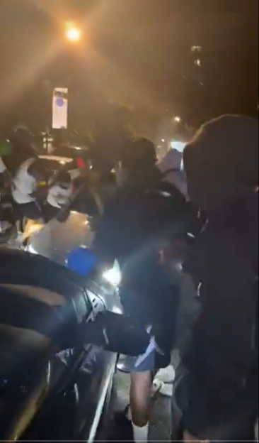 A gang attacking a car.