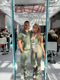 Two people posing in front of a Bio Science display.