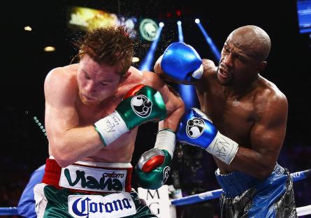 Floyd Mayweather Jr. throwing a right punch at Canelo Alvarez during a boxing match.