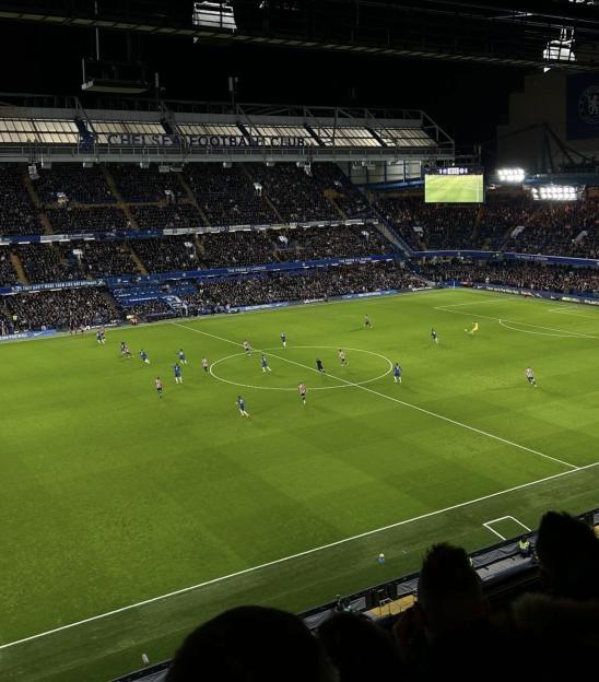 Soccer game in a stadium filled with spectators.
