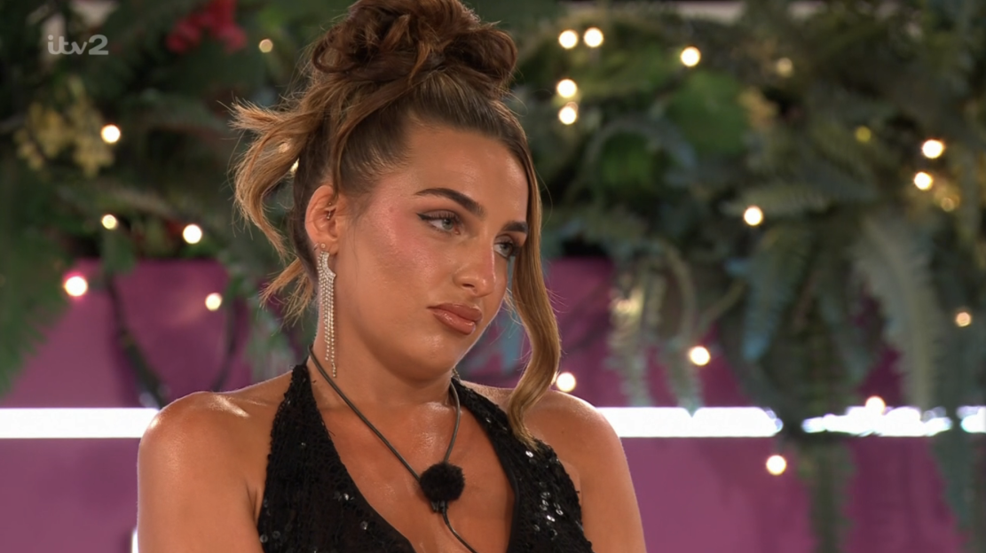 Screenshot of a woman with a serious expression.