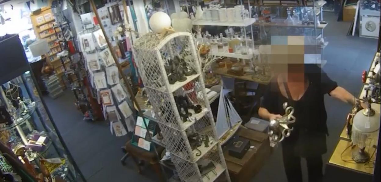 Security camera footage of a person in a shop examining merchandise.