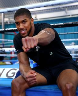 Anthony Joshua poses for photographers after a training session.