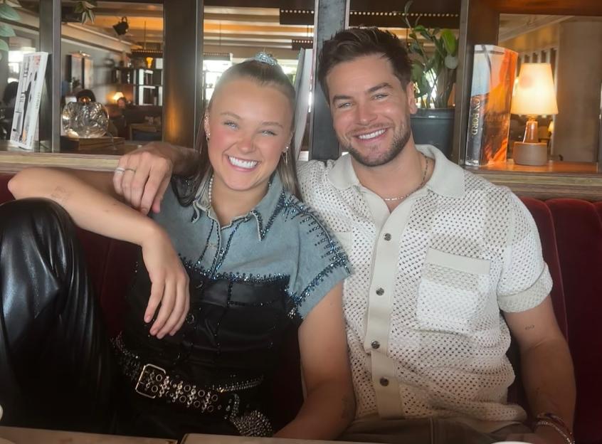 A smiling couple sitting on a red couch.