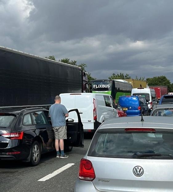 Traffic jam on a highway under a cloudy sky.