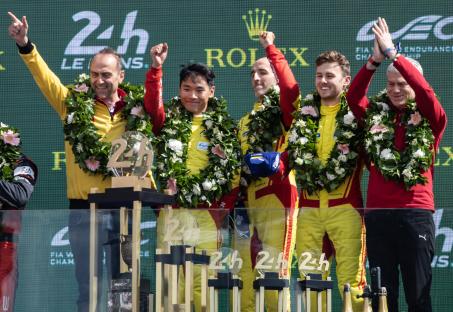 AF Corse racing team celebrating a victory on a podium.