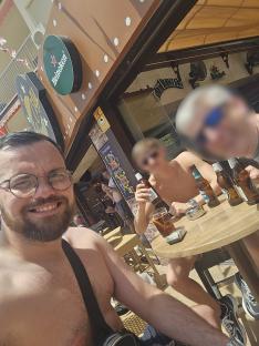 Man with glasses and beard at a bar in Benidorm, Spain.