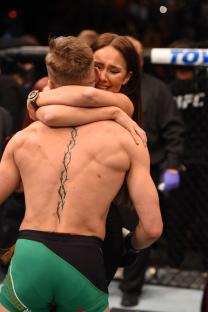Conor McGregor embracing his girlfriend after a UFC victory.