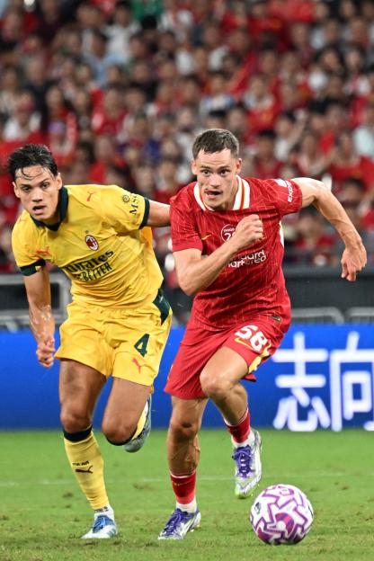 Liverpool's Florian Wirtz pursued by AC Milan's Samuele Ricci during a football match.