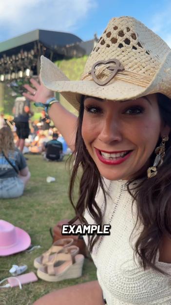Woman in a straw cowboy hat at an outdoor concert.