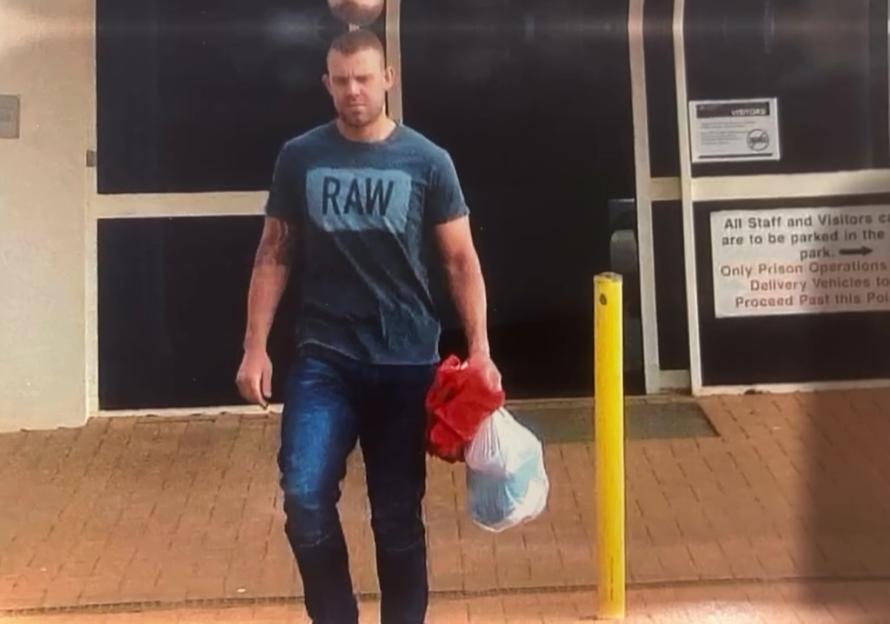 Man wearing a RAW shirt carrying bags.
