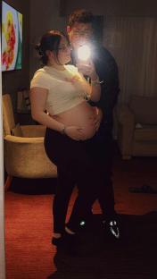 Pregnant woman and her partner taking a selfie.