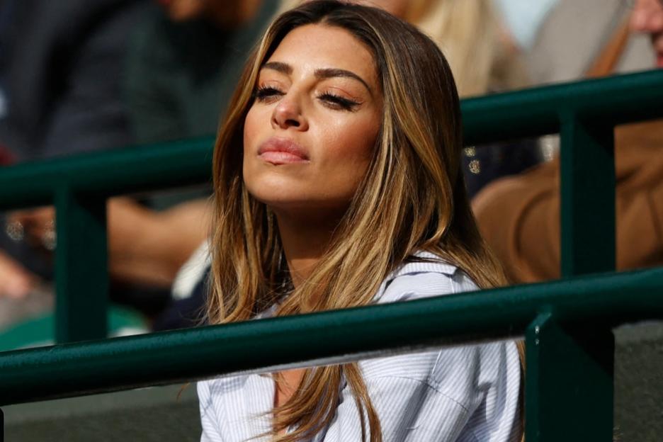 Woman with long brown hair sitting in a stadium.