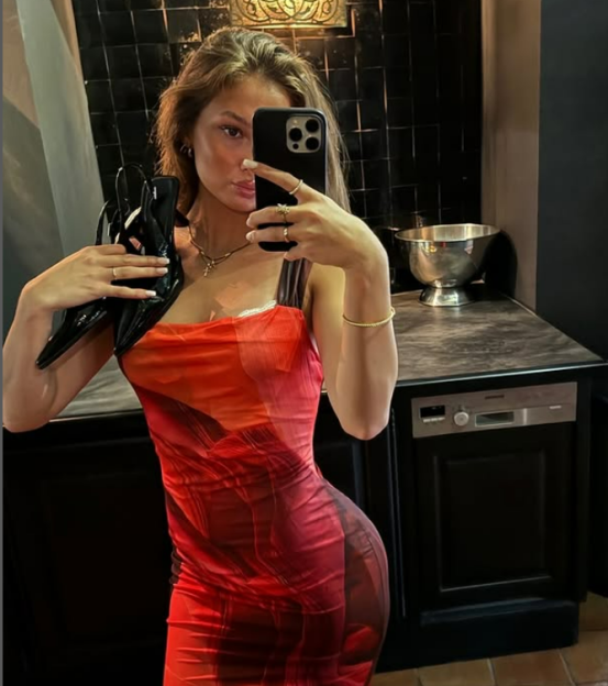 Woman in red dress taking a selfie.