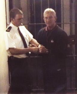 Police officer handcuffing Kenneth Noye in custody.