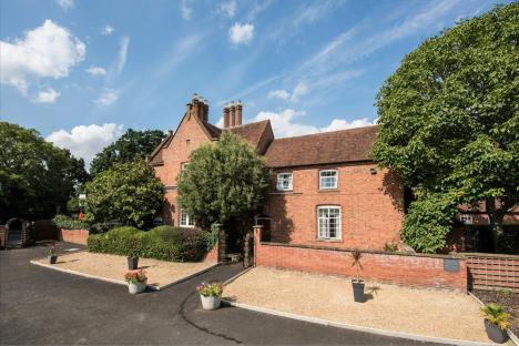 Brick house with landscaping and a driveway.