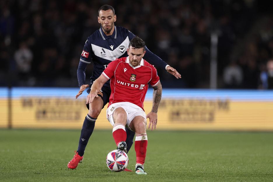 Soccer players compete for the ball.