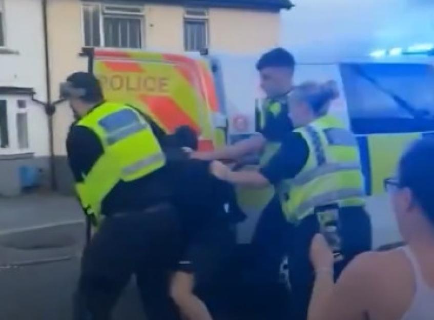 Police officers arresting a biker.