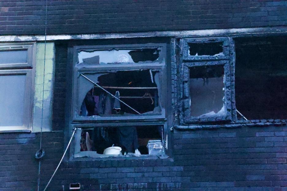 Fire-damaged windows of a brick building.