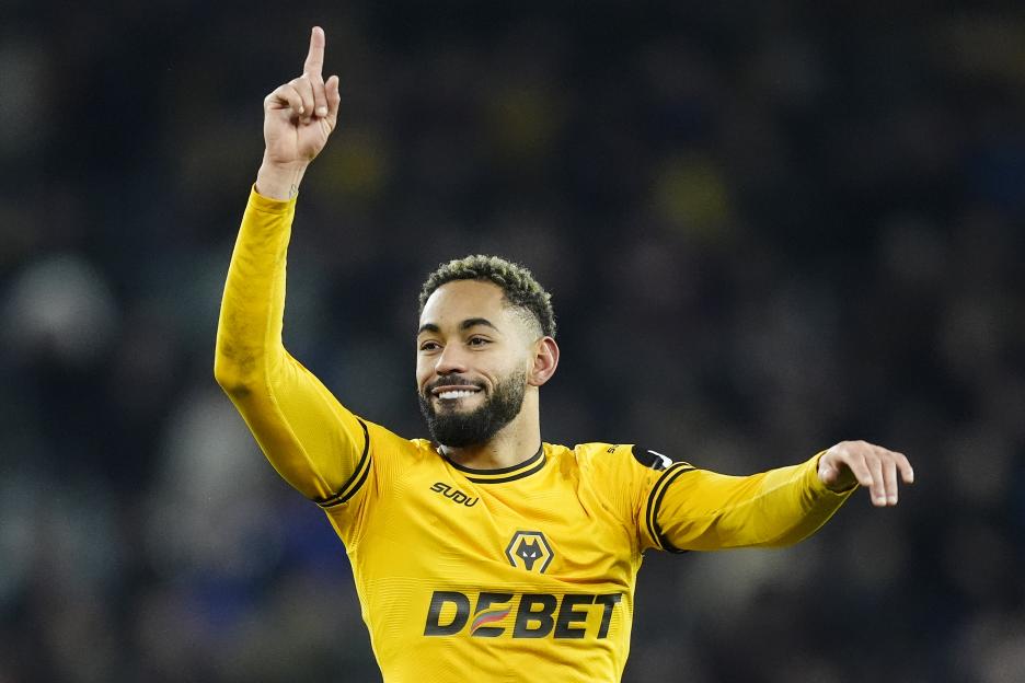 Matheus Cunha celebrates in a yellow soccer jersey.