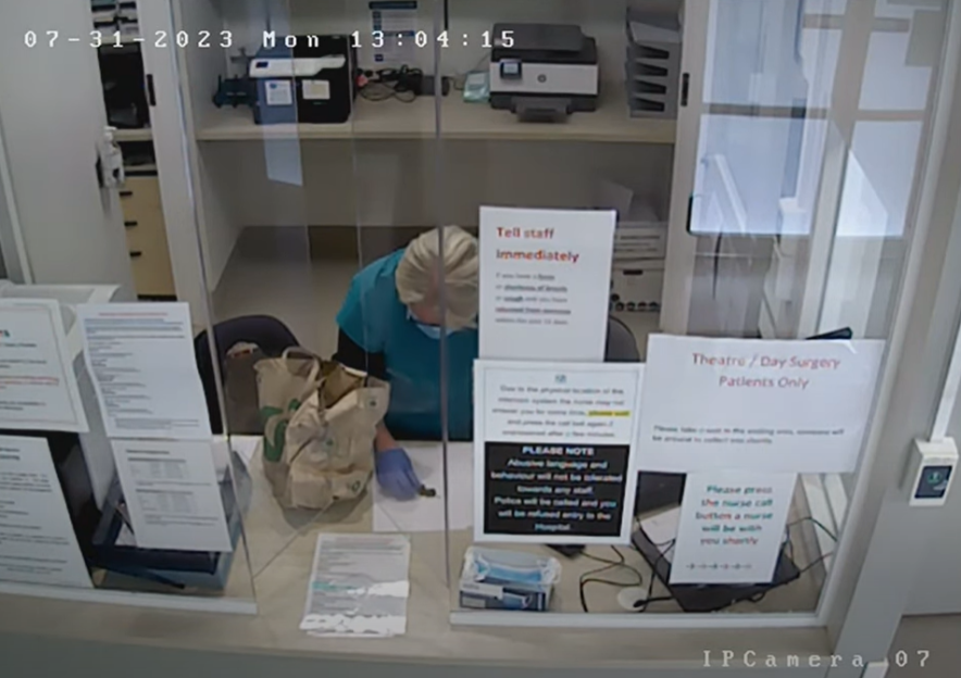 Hospital employee working at a reception desk.