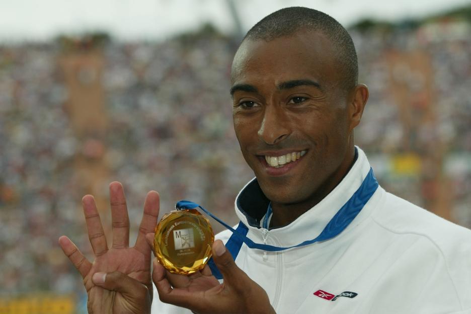Athlete holding up his gold medal.