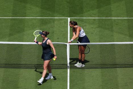 Two tennis players at the net, one arguing with the umpire.