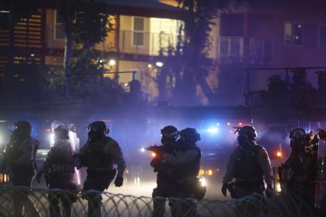 Protesters clashing with law enforcement during a demonstration against immigration raids.