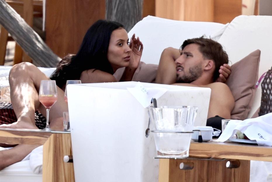 Maya Jama and Ruben Dias relaxing on a sunbed at a beach club.