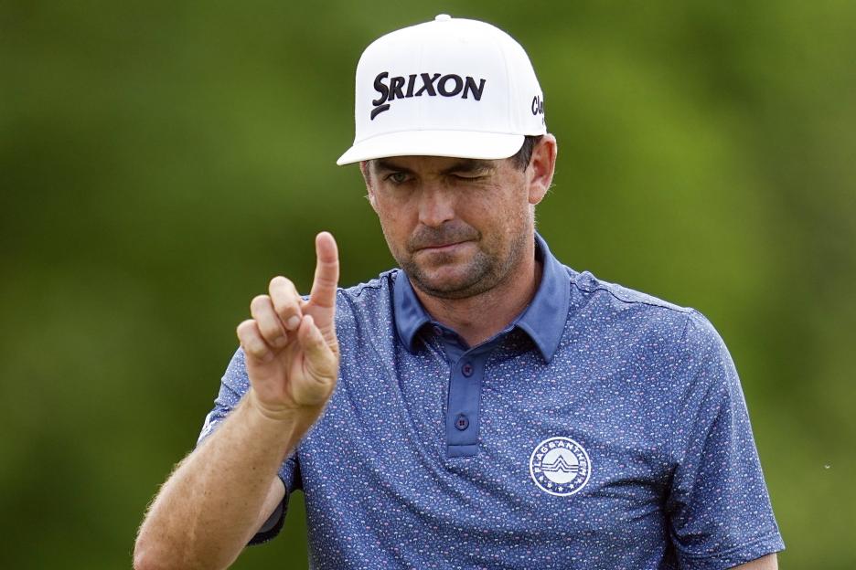 Keegan Bradley, wearing a Srixon hat, lines up a putt.
