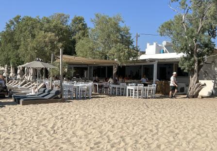 Beach restaurant with white tables and chairs.