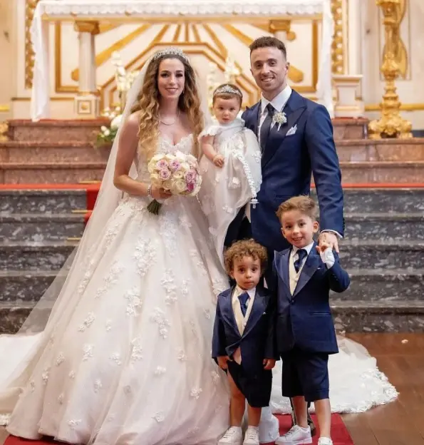 Wedding photo of a bride and groom with their three children.