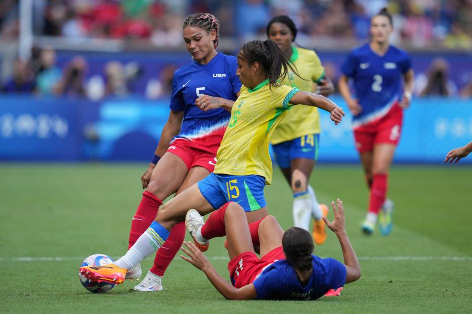 Brazilian and US women's soccer players vying for the ball.