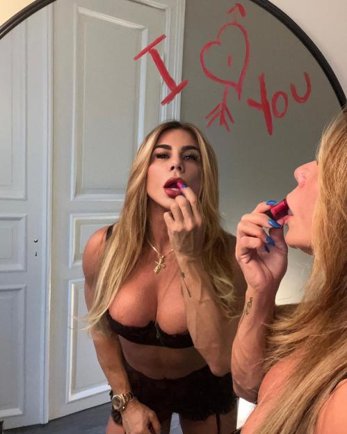 Woman applying lipstick in a mirror with