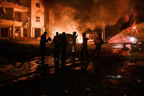 Firefighters and rescue personnel at a fire following a missile attack.