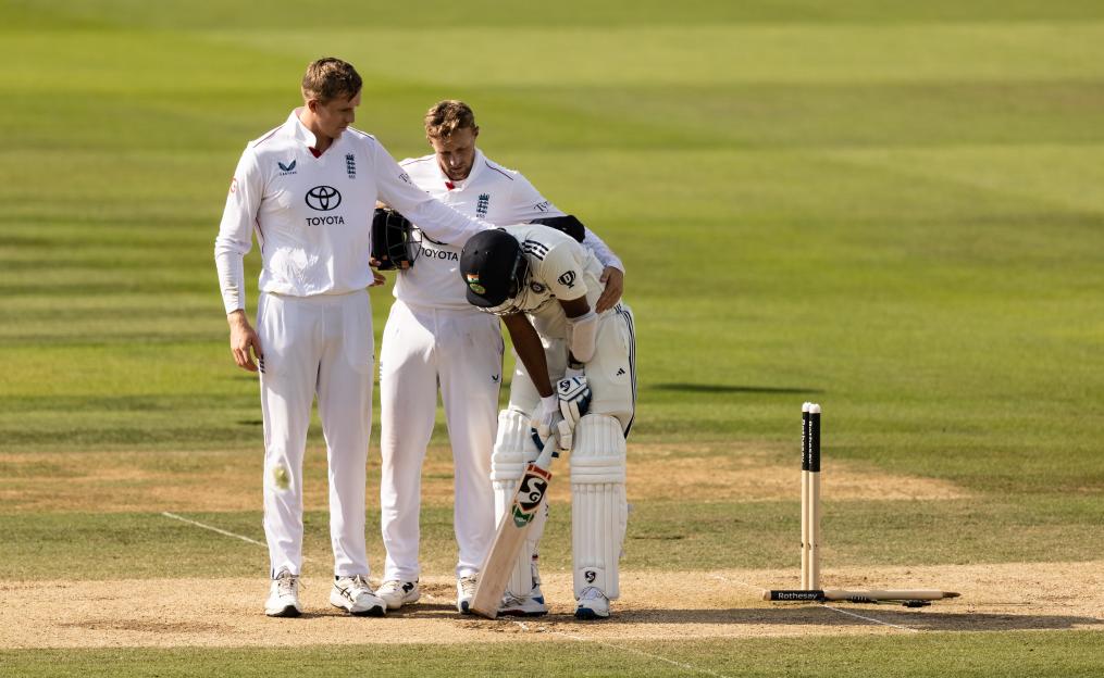 Cricket players consoling a distraught teammate.