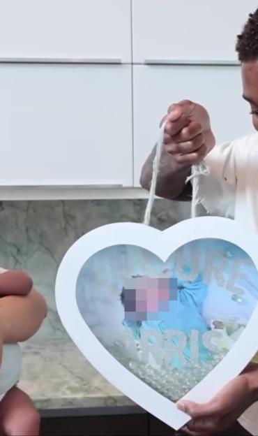 Parents reveal their baby's name in a heart-shaped frame.