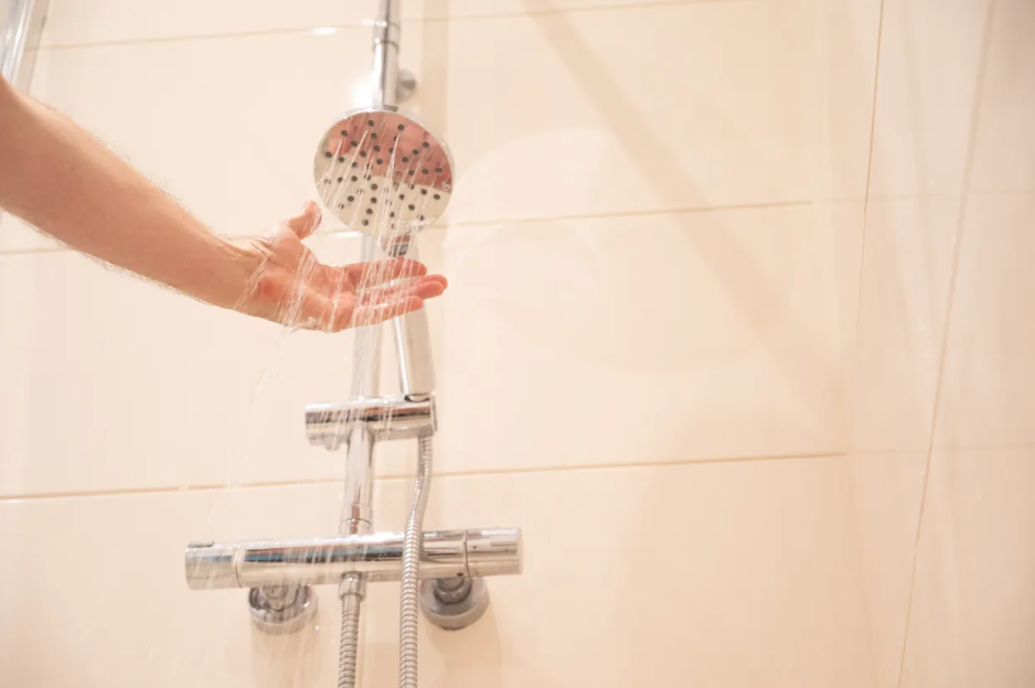 Hand under a shower head.