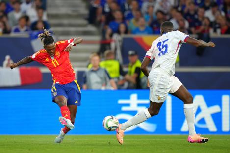 Nico Williams of Spain shoots the soccer ball while being defended by Ibrahima Konate of France.
