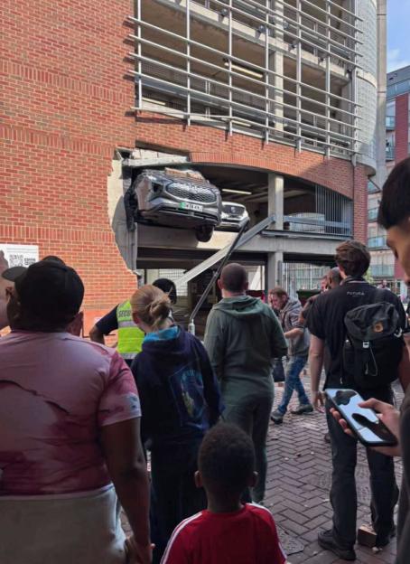 Car crashes through multi-story car park, injuring pedestrians.