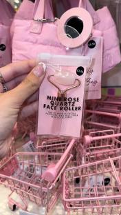 Mini rose quartz face roller in pink packaging.