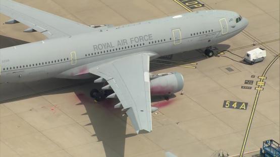 Royal Air Force plane with paint splattered on its wing and engine.
