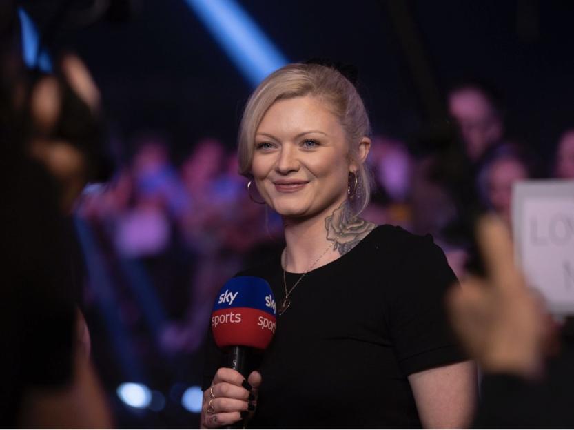 Sky Sports presenter holding a microphone.