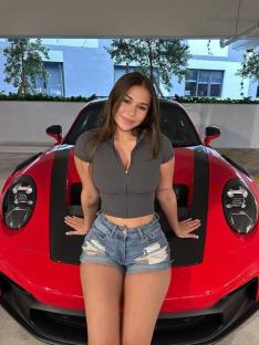 Woman posing on a red sports car.